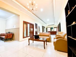 a living room with a couch and a table at Homey Guesthouse near Sby Zoo Syariah in Surabaya