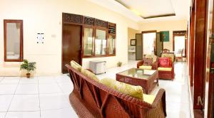 a living room with couches and a table at Homey Guesthouse near Sby Zoo Syariah in Surabaya