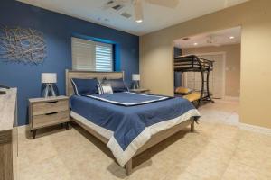 a bedroom with a bed with a blue wall at Huge 6 Bedroom with Pool, Spa, 85 Inch TV, Game Room in Houston +30 photos