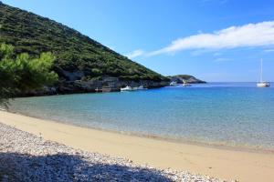 een zandstrand met boten in het water bij Apartments by the sea Cove Salbunara - Bisevo, Vis - 12700 in Komiža