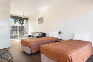 una camera con due letti e un soggiorno di Smart Stayzzz Inns a Clermont