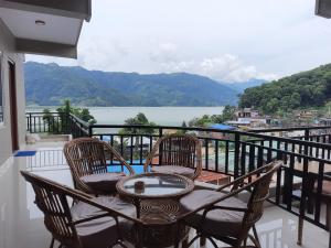una mesa y sillas en un balcón con vistas en The Eagle Zone, en Pokhara