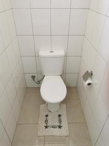 - une salle de bains blanche avec toilettes et tapis dans l'établissement Royal Studio, à Flic-en-Flac