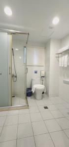 a bathroom with a shower and a toilet in it at Ximen Garden Inn in Taipei