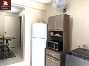 a kitchen with a white refrigerator and a table at Oasis Living Getaway in Mandeville, Manchester in Mandeville