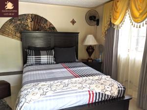 a bed with a wooden headboard in a bedroom at Oasis Living Getaway in Mandeville, Manchester in Mandeville