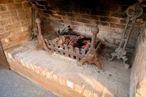 un horno de ladrillo con un fuego dentro de él en Luxury Modern Farm Stay Home in Southern Highlands en Joadja Creek