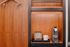 a cupboard with a radio and a coffee mug at Aloft London Excel in London