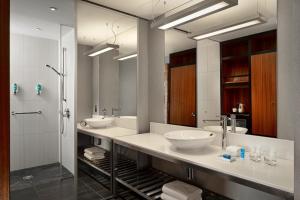 a bathroom with two sinks and a shower at Aloft London Excel in London