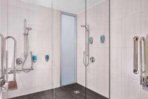 a bathroom with a shower with a glass door at Aloft London Excel in London