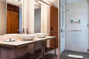 a bathroom with two sinks and a shower at Aloft London Excel in London