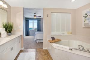 a bathroom with a tub and a bedroom with a bed at Vitamin Sea - Modern Beach Highrise At Ocean Walk Resort Daytona Beach in Daytona Beach