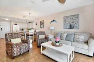 een woonkamer met een bank, stoelen en een tafel bij Vitamin Sea - Modern Beach Highrise At Ocean Walk Resort Daytona Beach in Daytona Beach