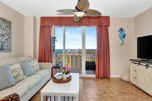 a living room with a couch and a large window at Vitamin Sea - Modern Beach Highrise At Ocean Walk Resort Daytona Beach in Daytona Beach