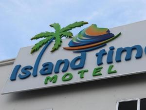 a sign for a island inn motel with a palm tree at ISLAND TIME MOTEL KUAH in Kuah