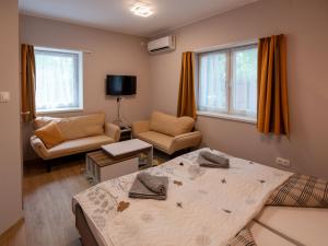 - une chambre avec un lit et un salon avec un canapé dans l'établissement Levendula vendégház, à Szentes