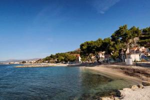 a view of a beach with trees and the water at Apartments with WiFi Podstrana, Split - 15970 in Podstrana