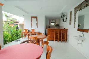 Kadek Bagus Guesthouse Denpasar Mitra RedDoorz في كيروبوكان: غرفة طعام مع طاولة وكراسي ومغسلة