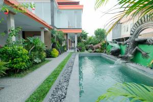 Kadek Bagus Guesthouse Denpasar Mitra RedDoorz في كيروبوكان: بيت فيه مسبح قدام بيت