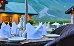 een tafel met witte servetten en borden erop bij Arco Hotels & Resorts sonamarg in Sonāmarg