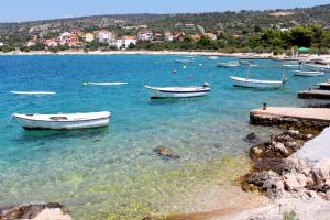 a group of boats in the water near a beach at Apartments by the sea Cove Ljubljeva, Trogir - 2194 in Voluja