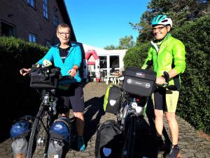 un hombre y una mujer de pie junto a sus bicicletas en Thisted Øst Bed & No Breakfast, en Thisted