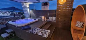 - une baignoire sur le balcon avec une planche de surf dans l'établissement Hotel Mallas, à Nea Kallikratia