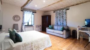 a living room with a bed and a couch at A Casa di Anna in Cortemilia