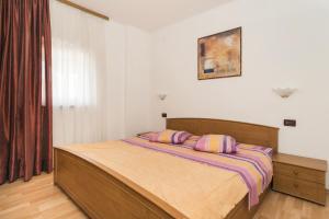 a bedroom with a bed with two pillows on it at Apartments with a parking space Zambratija, Umag - 2533 in Savudrija