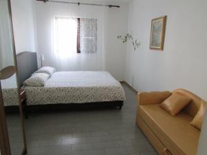 1 dormitorio con cama, sofá y ventana en Apartments by the sea Umag - 2528 en Umag