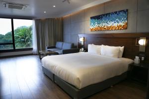 um quarto de hotel com uma cama grande e uma cadeira em Brightland Resort & Spa em Mahabaleshwar