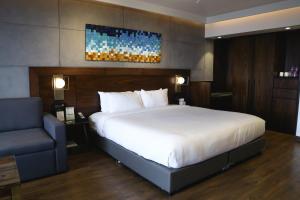 a bedroom with a large bed and a blue chair at Brightland Resort & Spa in Mahabaleshwar
