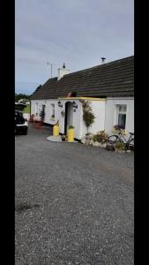 a white house with a car parked in front of it at Toddys Cottage & Stables in Cavan