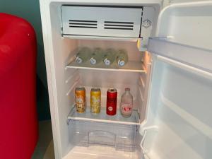 an open refrigerator with drinks and sodas in it at Le Petit Saint Tropez in Khanom