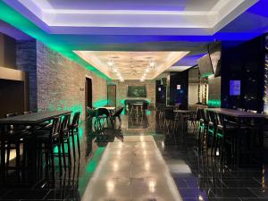 a restaurant with tables and chairs and green lights at The Light Hotel Penang in Perai