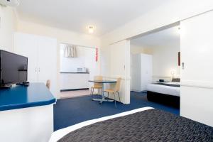 a hotel room with a bed and a desk with a table at Applegum Inn in Toowoomba