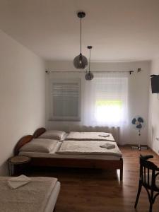 a bedroom with a large bed and a window at Borbély apartman in Nagykanizsa