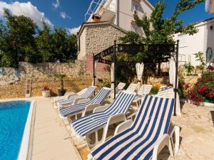 eine Gruppe von Liegestühlen neben einem Swimmingpool in der Unterkunft Villa Stil in Trogir