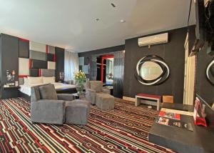 Habitación de hotel con cama y espejo en Swiss-Belcourt Makassar, en Makassar