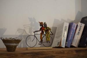 a figurine of a cat riding a bike next to books at Africa Amini Homes in Nkoaranga