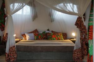 a bedroom with a bed with a canopy and curtains at Africa Amini Homes in Nkoaranga