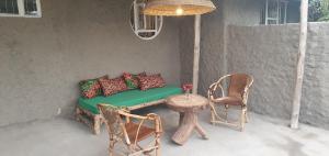 NkoarangaにあるAfrica Amini Homes - Africa Amini Lifeのソファ、テーブル、椅子付きのポーチ