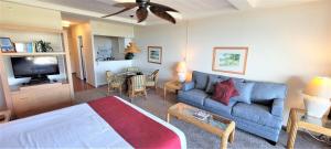a living room with a blue couch and a table at Whaler #763 Condo in Lahaina