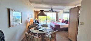 a hotel room with a bed and a table and chairs at Whaler #763 Condo in Lahaina