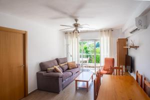 ein Wohnzimmer mit einem Sofa und einem Tisch in der Unterkunft San Juan Live in Alicante