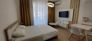 una camera con letto, scrivania e TV di Casa Al Mare Premium Residences a Rafailovici