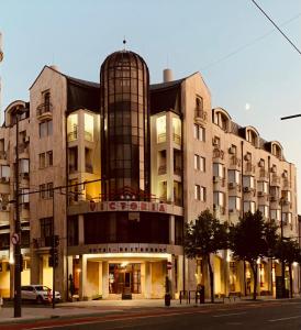 een groot gebouw in een stadsstraat bij Hotel Victoria in Cluj-Napoca