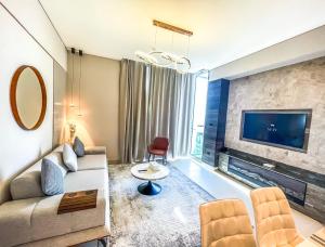 een woonkamer met een bank en een tv bij STAY BY LATINEM Luxury 2BR Holiday Home CV B2513 near Burj Khalifa in Dubai