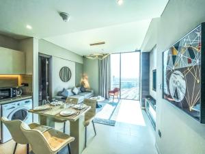 eine Küche und ein Wohnzimmer mit einem Tisch und Stühlen in der Unterkunft STAY BY LATINEM Luxury 2BR Holiday Home CV B2513 near Burj Khalifa in Dubai