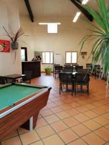 Campotel Du Jaur في Saint-Pons: طاولة بلياردو في غرفة مع طاولات وكراسي